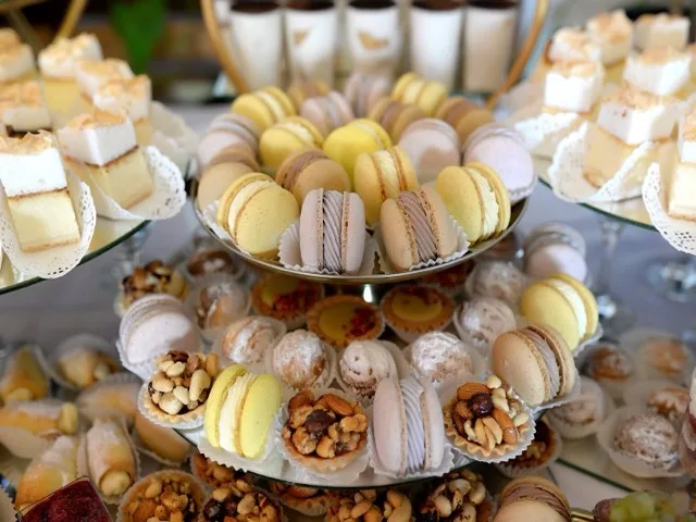 Válogatott cukrászati sütemények és macaronok tálcán